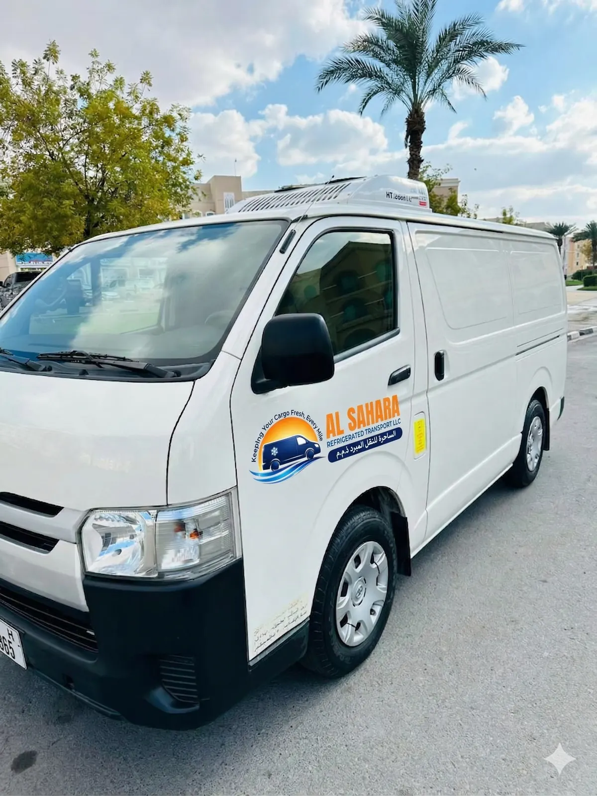 Front three-quarter view of an Al Sahara refrigerated Toyota Hiace van with a Thermo King roof unit, Abu Dhabi